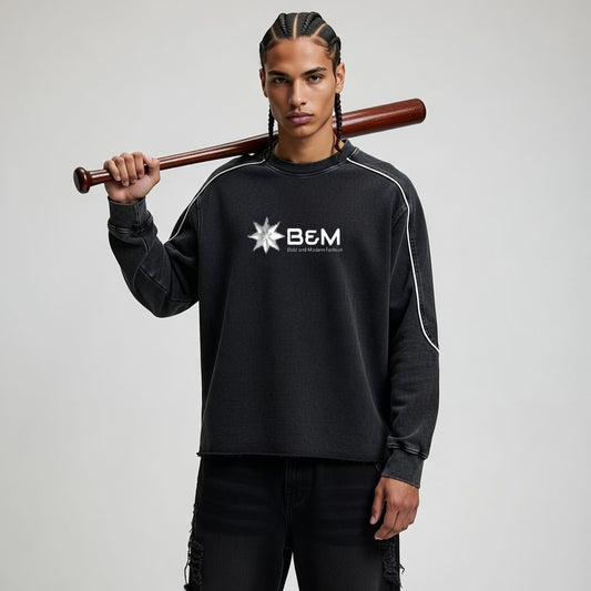Person wearing a black sweatshirt with 'B&M' logo holding a baseball bat against a gray background
