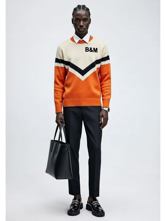 Person wearing an orange and white sweater with 'B&M' logo, holding a black bag on a light gray background